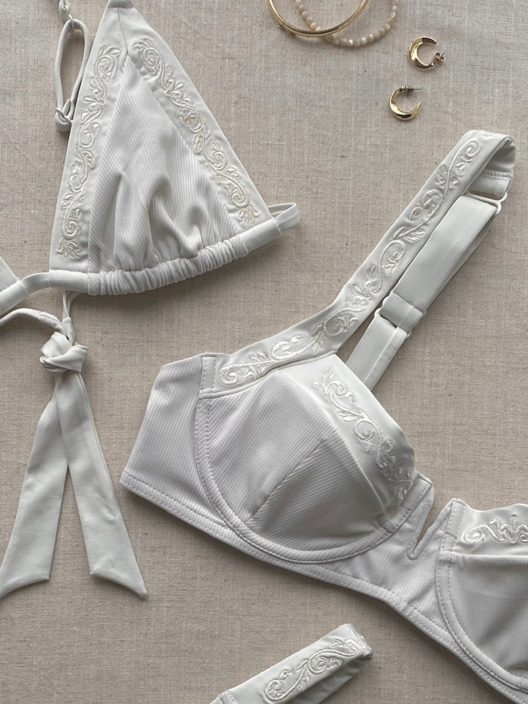 Bikini top balcony in ivory white with golden jewellery on linnen towel